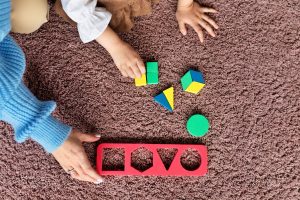 i_top-view-teacher-helping-kid-learn